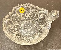 Top view of clear pressed glass dish showing starburst pattern and handle