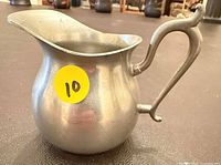 Full view of pewter creamer showing shape, spout and handle