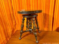 Full view of antique wooden piano stool on table