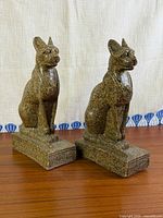 Front view of both Bastet cat bookends on wood surface