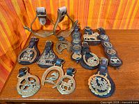 Full lot showing pair of spurs, multiple leather straps with brasses, and loose drops