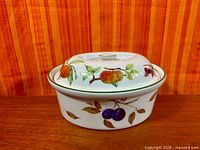 Covered casserole front view showing fruit motifs and lid