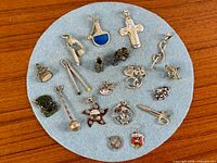 Full group view of all sterling silver charms and pendants on blue felt background