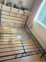 Full view of assembled metal bed frame showing headboard, footboard, slats, center support