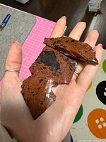 Three irregular reddish-brown obsidian chunks on hand