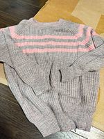 Full view of grey sweater with pink stripes