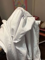 Folded white stretch knit fabric shown draped