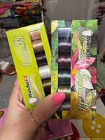 Front view of both unopened WonderFil InvisaFil thread boxes showing assorted spool colours