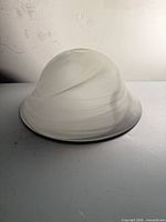 Side profile of frosted glass bowl shade with gray swirl
