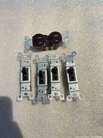 front view of 4 toggle switches and 1 duplex receptacle