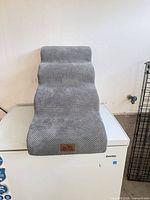 Front angled view of gray 3-step pet stairs showing step surfaces and fabric texture
