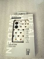 Front of sealed retail package showing clear case with gold hearts and MagSafe ring