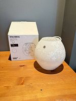 Box and glass globe lamp shade on table