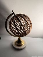 Front view of jute rope globe on brass stand and marble base