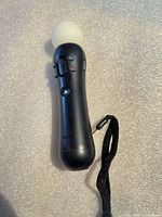 Full view of controller front showing buttons, orb, wrist strap