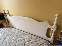 Front view of cream wood double headboard against wall