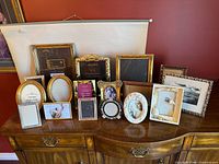 All frames grouped on dresser showing variety of sizes and finishes