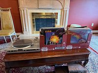 Turntable on coffee table beside two boxes of vinyl records