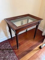 full view of table showing glass top and wooden frame