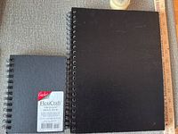 Both sketchbooks side by side with ruler for scale