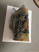 Full stein left side showing floral relief and handle