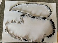 Two silver-tone necklaces with crystal and faceted black beads