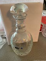 Full view of crystal decanter with stopper inserted, showing cut pattern and clarity