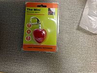Front of sealed package showing red heart alarm keychain