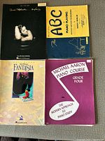 Front covers of all four music books displayed