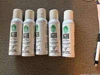 Front view of five sealed After Inked spray bottles