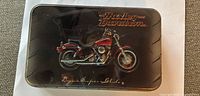 Top of collector tin showing red Dyna Super Glide motorcycle graphic and Harley-Davidson logo