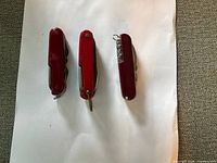Front view of three red multi-tool knives closed