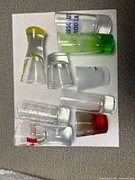 Nine assorted shot glasses arranged on paper