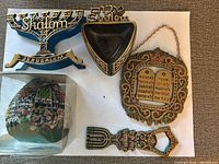 Front view of all five items: napkin holder, ashtray, Ten Commandments plaque, sealed candle, bottle opener