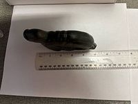 Top view of soapstone seal beside ruler showing length