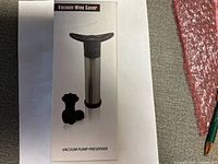 Front of boxed vacuum wine saver showing pump and stoppers
