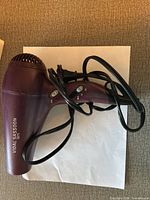Full view of purple Vidal Sassoon 1875 hair dryer with power cord