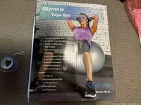 Front of sealed Glymnis yoga ball retail box showing model, size and anti-burst features
