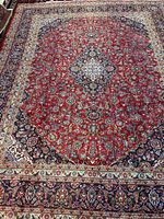 Full view of Kashan rug showing red field, borders and overall size
