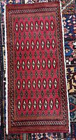 Full view of red Turkmen rug showing overall pattern and size