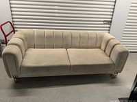 Front view of off-white two-seat sofa showing overall design and condition