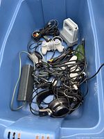All items laid in blue bin: controllers, Transfer Pak, power brick, headphones, cables