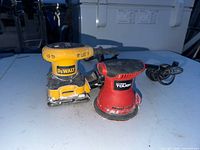 Front view of DeWalt palm sander and Hyper Tough orbital sander on table