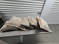 Five throw pillows on table showing mix of crushed velvet and chevron design