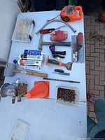 Overall view of all tools, hardware, caulk tubes, safety cone and organizer displayed on table