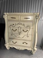 Front view of Versailles bone white chest showing five drawers and ornate carvings