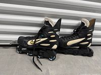 Side view of both skates showing overall design, graphics, size, and condition