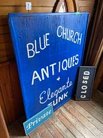 Full view of blue wooden sign showing complete text and scale.