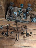 Group shot showing box of tall candlesticks, green wire holder, separate silver candlestick and wall sconce