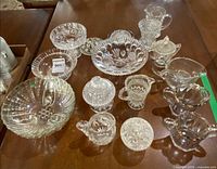 Group shot of all clear pressed glass pieces on table